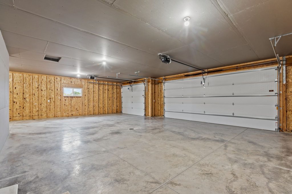 Spacious attached garage with multiple parking spaces and storage area