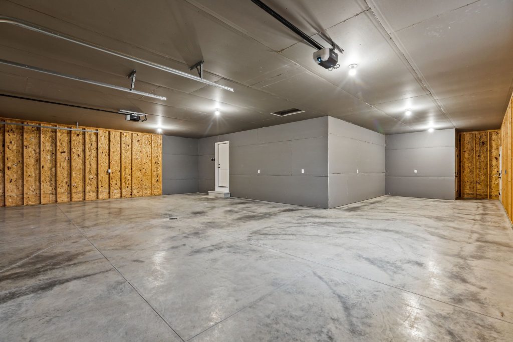Attached garage with multiple parking spaces and storage area